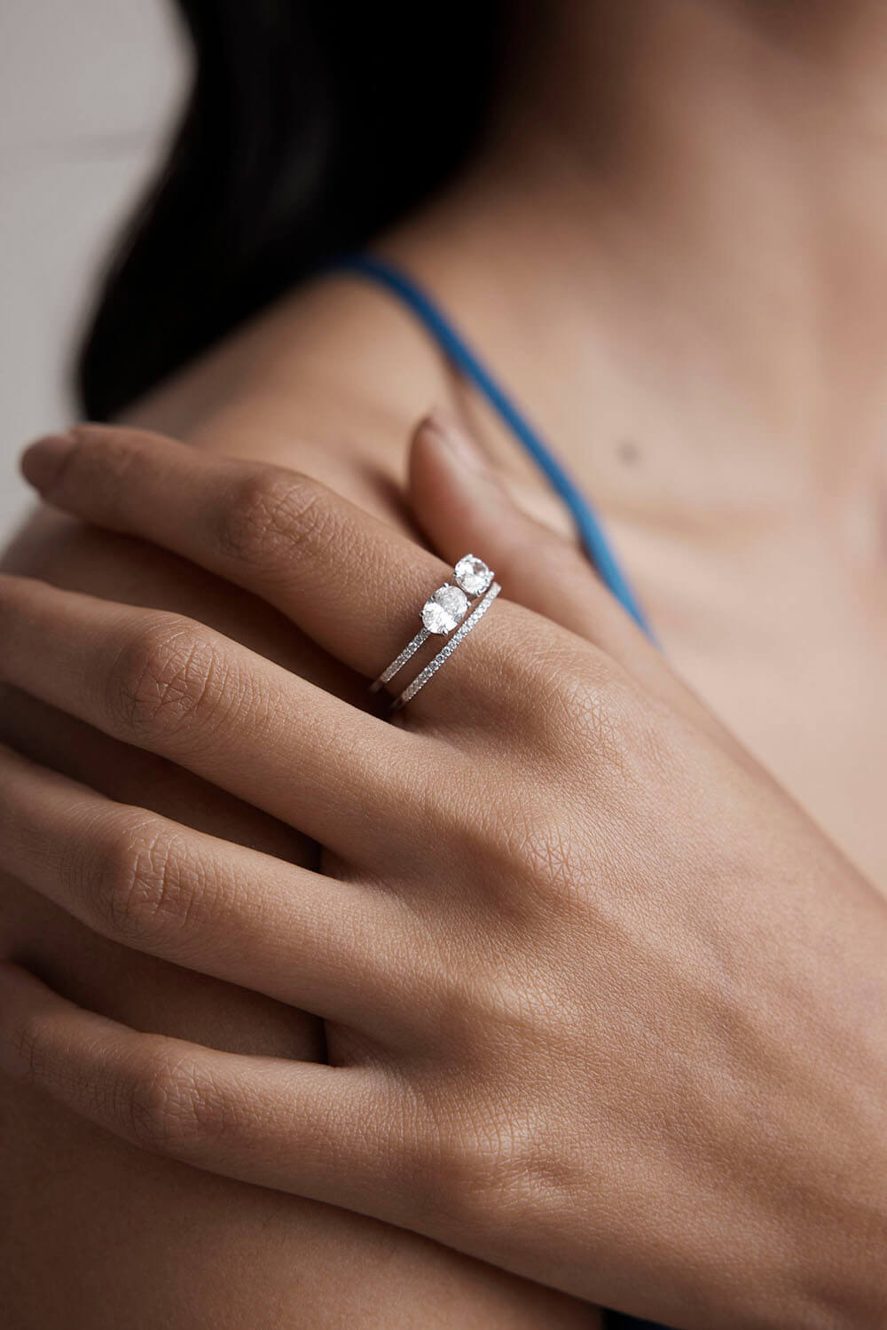 Close-up of a hand wearing two silver rings with a blurred background