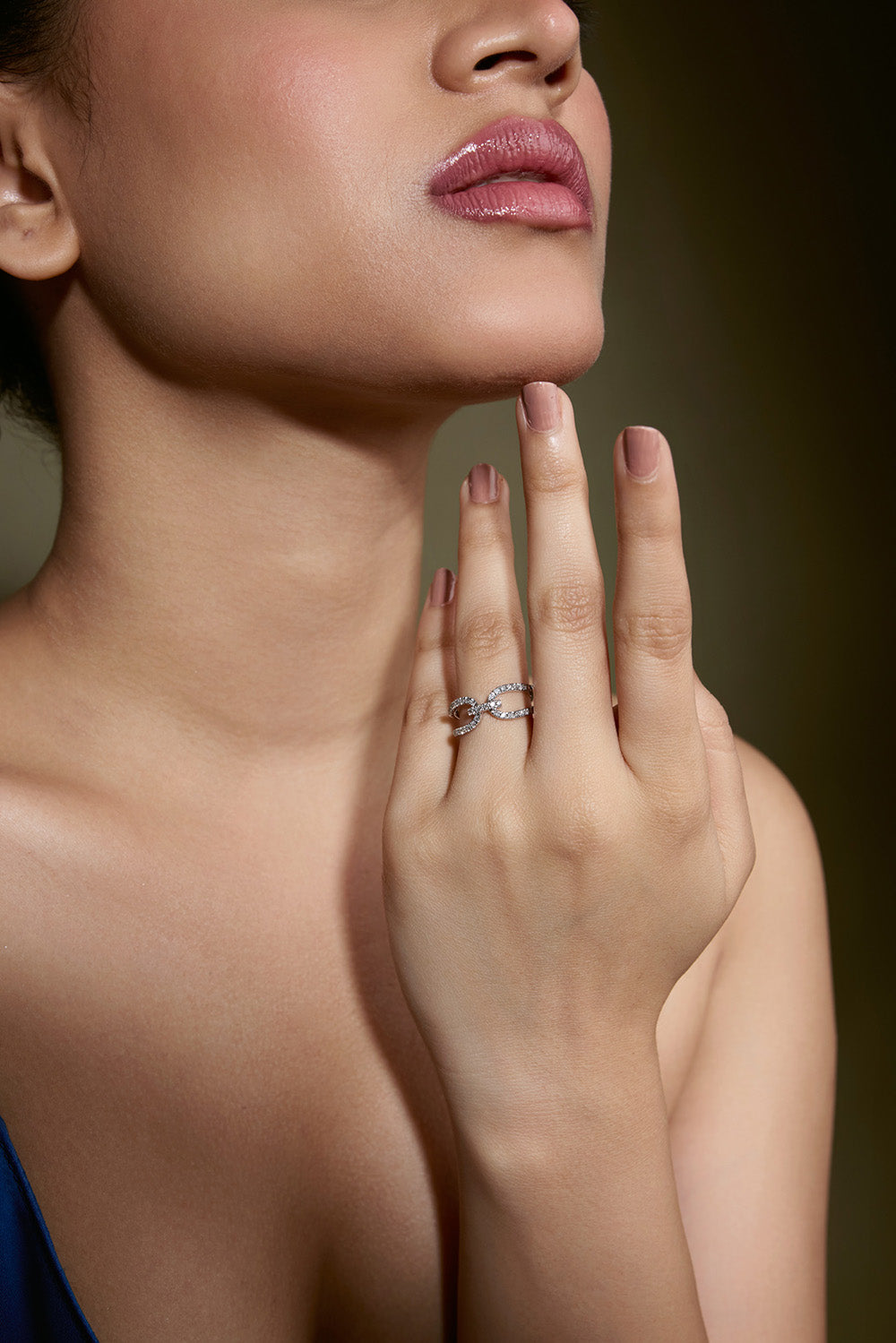 Close-up of a woman's hand with a diamond ring on a dark background