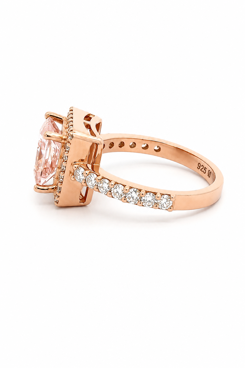A rose gold ring featuring a large oval pink gemstone in a prong setting, with a pavé band of small clear stones and a micro-pave halo, shown on a white background.