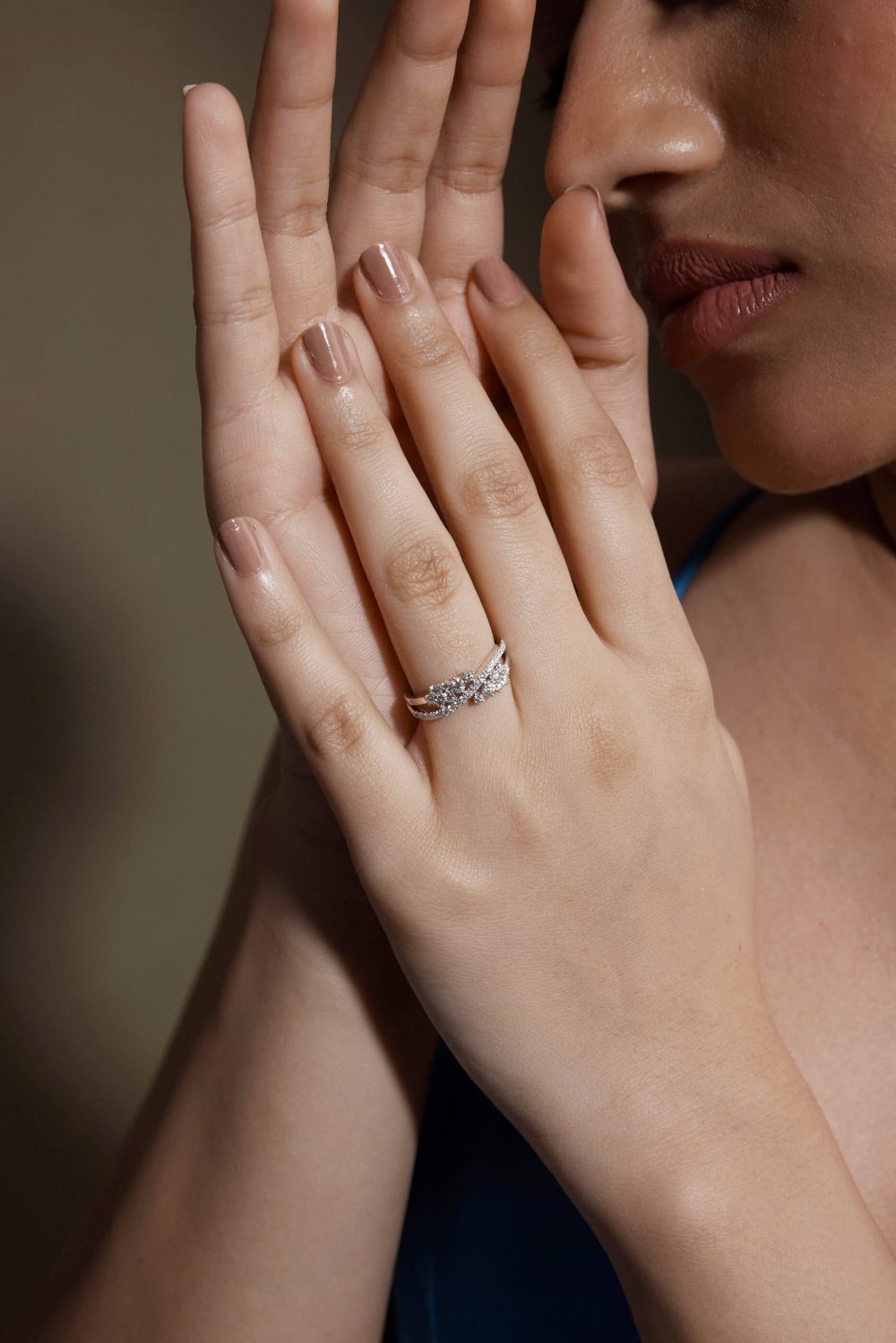 A person's hand with a ring on the finger, touching the nose slightly.